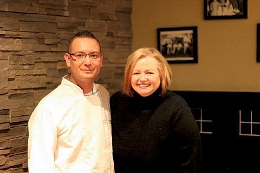 a chef in white uniform together with a Food Blogger wearing black