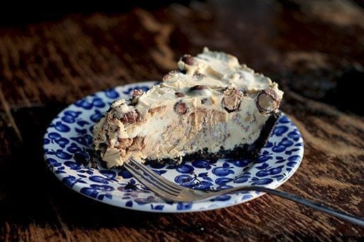Close up Slice of Ice Cream Peanut Butter Pie in a blue dessert plate on wood background