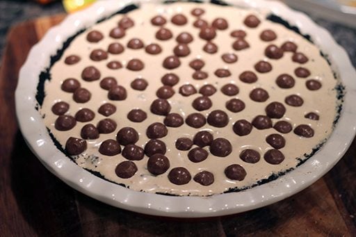 melted ice cream in the pie plate with Reese's Bites on top