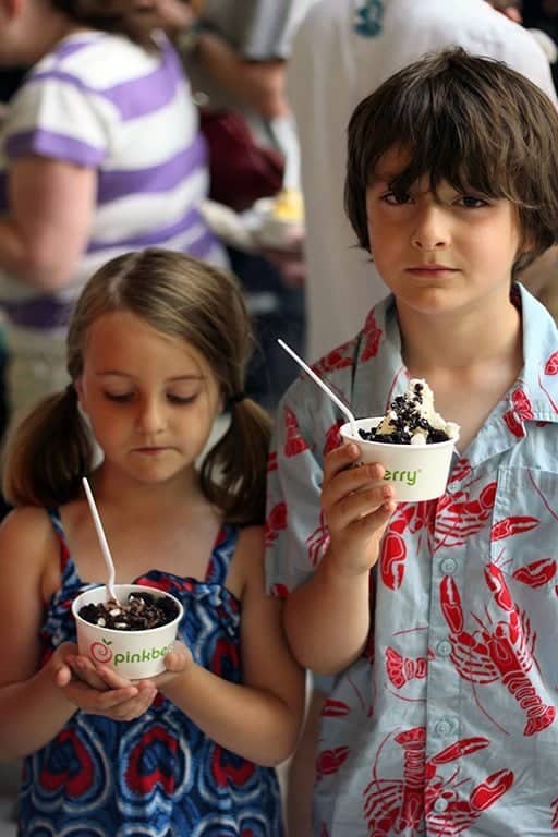 little girl and boy holding each a cup of Pinkberry frozen yogurt topped with chocolate
