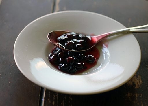 Saskatoons berry mixture with cornstarch in a white plate with spoon