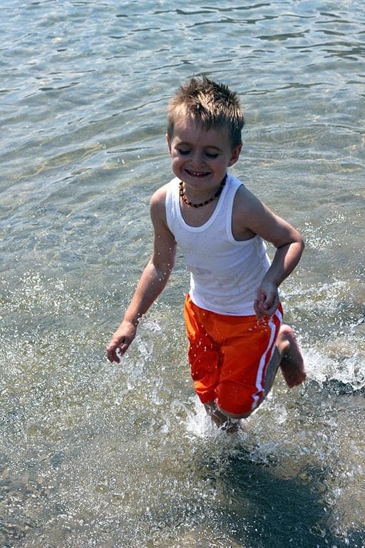 little boy enjoying the water on the lake