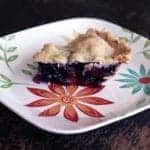 close up slice of Blueberry Rhubarb Pie in a white plate with floral design