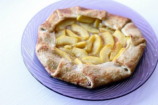 Drunken Peach Galette in a glass plate on white background