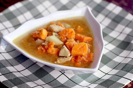 Potato Soup with Chicken and chunky sweet potatoes in triangular soup bowl on a checkered plate