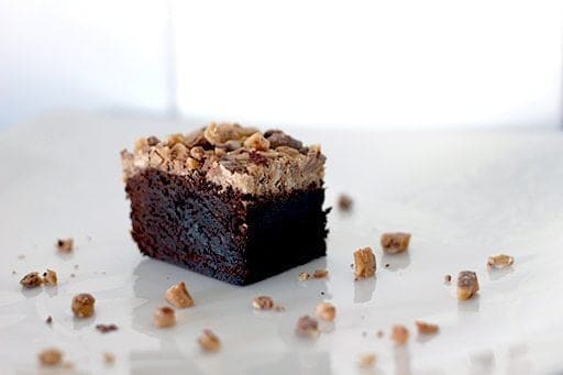 a piece of Heath Toffee Brownies topped with toffee crunch on white background