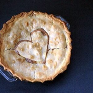 Peaches & Cream Pie in a pie dish with heart shape on top crust