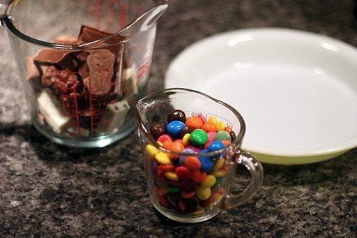 a cup of chopped mini chocolate bars, assorted Smarties and a shallow pie dish