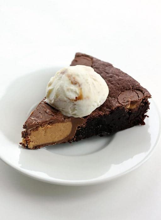 a slice of Giant Reese's PB Cup Skillet Brownie topped with a scoop of vanilla ice cream