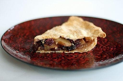 red rose printed plate with a slice of winter fruit pie