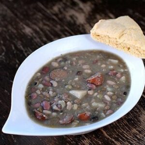 Bean, Potato and Sausage Soup in a White Soup Bowl with a slice of bread on side