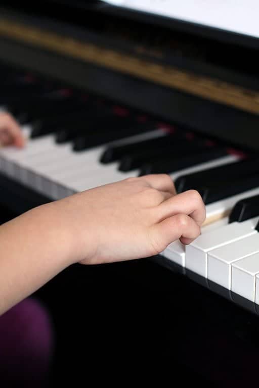 kid's finger on the keys of the piano