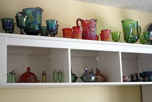 a collection of carnival glasses on top oh white shelving