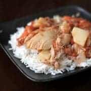 Chicken & Potato Stew on top of rice in a black plate bowl