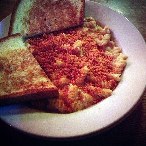 Doritos topped Mac n' cheese in plate with bread toast