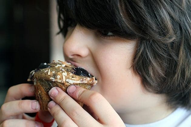 young boy having a bite of whole wheat muffin