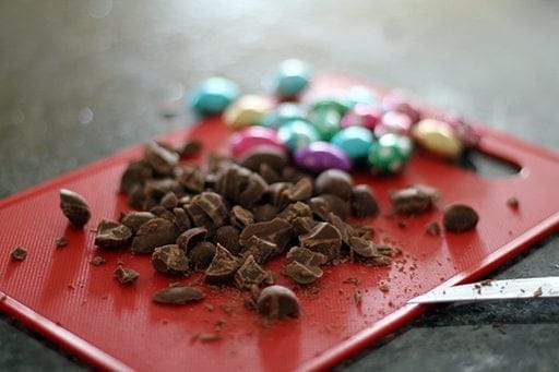 chopped chocolate candies in a red chopping board