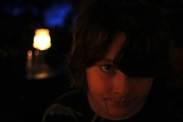 close up of young boy inside the restaurant on dark background