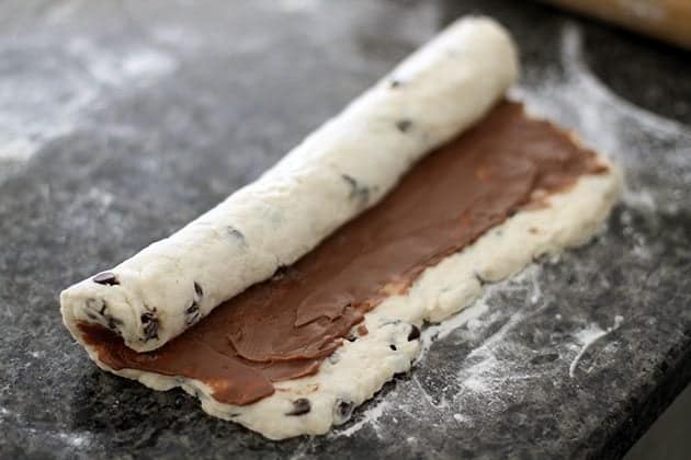 Rolling up the dough of chocolate cream cheese breakfast biscuits