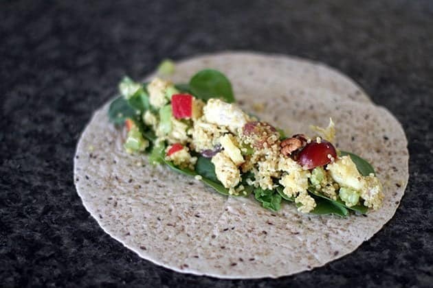 close up of quinoa wrap with spinach leaves at the center and filling on top of it