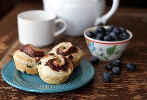 Three Pieces Philly Chocolate Cream Cheese Breakfast Biscuits in a Blue Plate and a Bowl of Fresh Blueberries