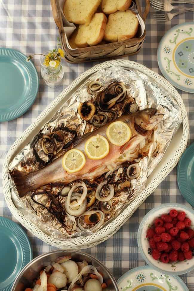 buttered and seasoned brook trout fillet and a basket of bread
