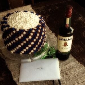 Simple Father's Day Cake with white and brown star icing, a bottle of whisky beside it