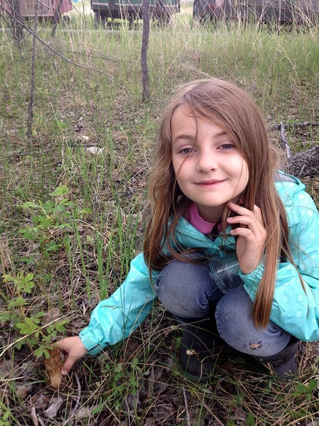 little girl picking up morel mushroom