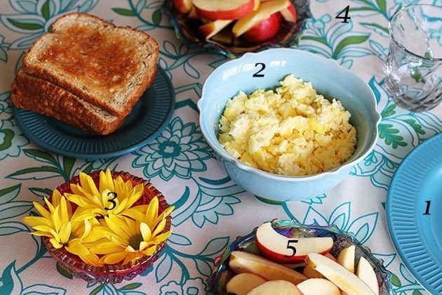 scrambled eggs, whole grain toast and sliced organic gala apples in the table for Sunday breakfast