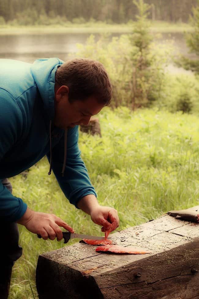 man slicing the brook trout