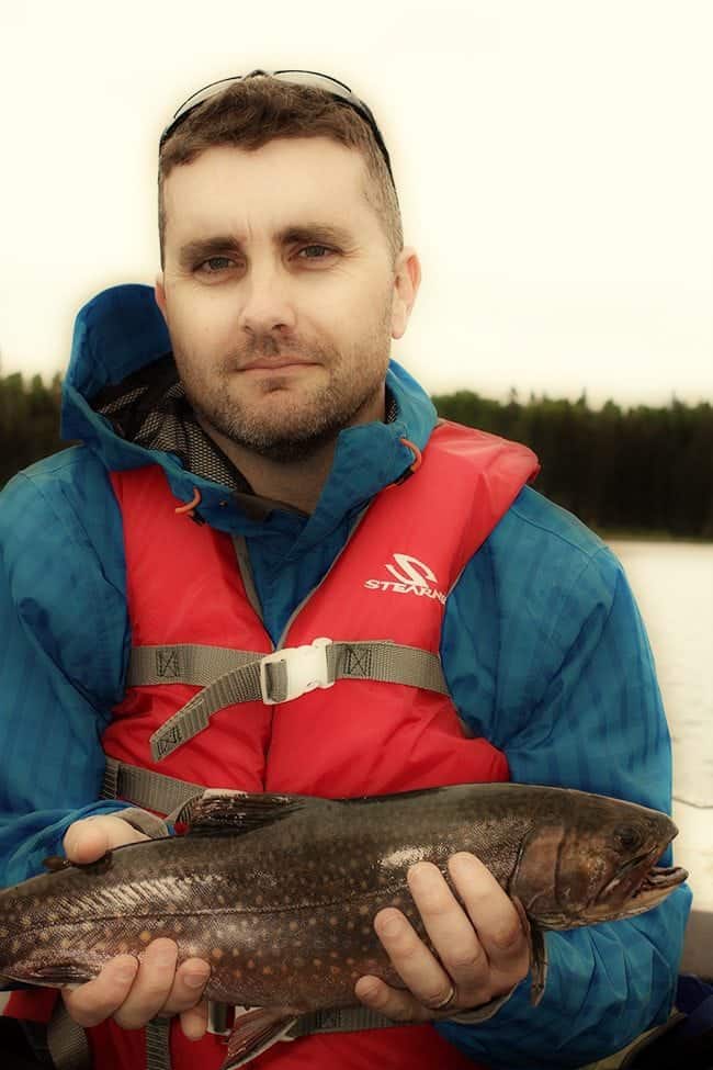 man holding brook trout with red and blue spots