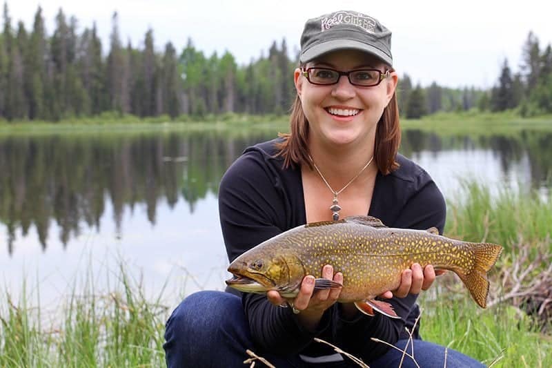 woman holding a big spotted brook trout