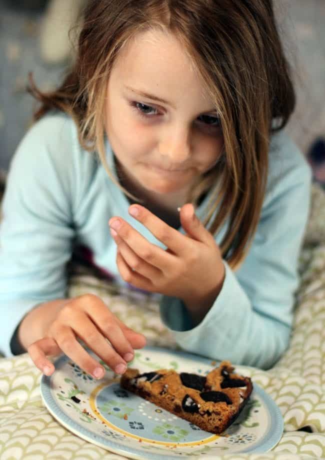 young girl eating her snack - in bed while watching the movie