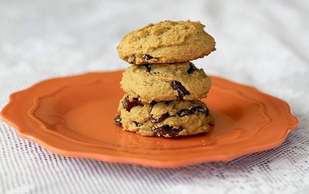 stack of Raisin Molasses Gems Cookies in an orange plate on white background