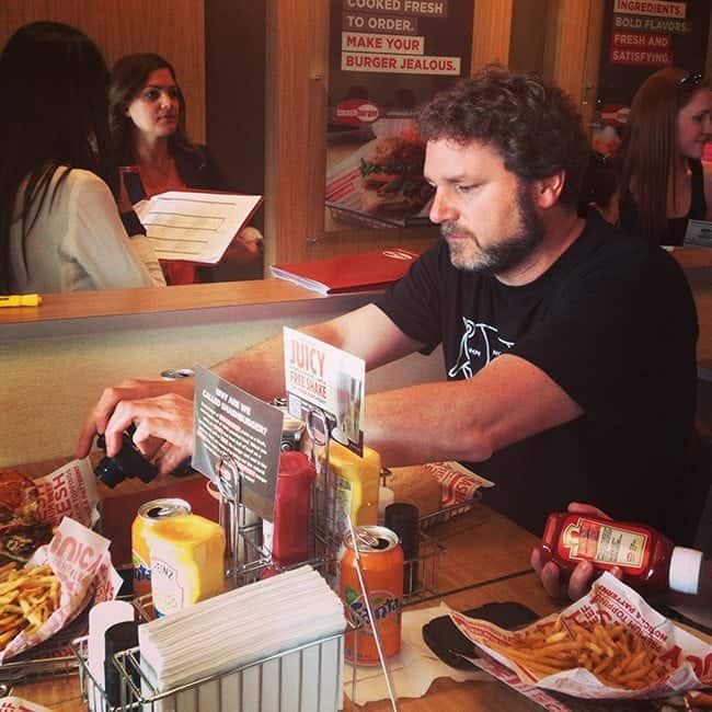 man in black shirt taking his food pictures