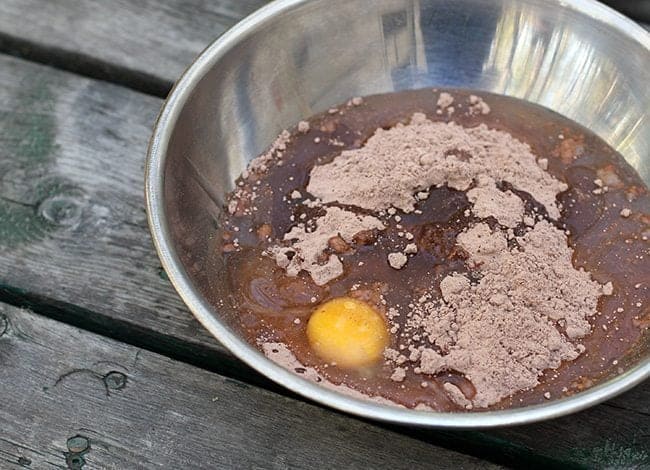 preparing the brownie mix, adding the egg