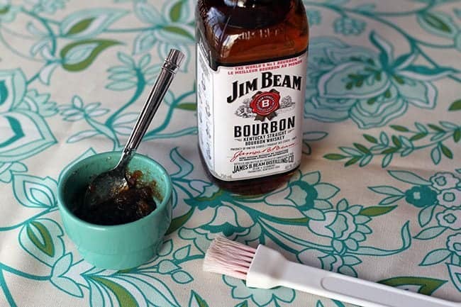 Bottle of Jim Beam brand bourbon and a cup of bacon jam