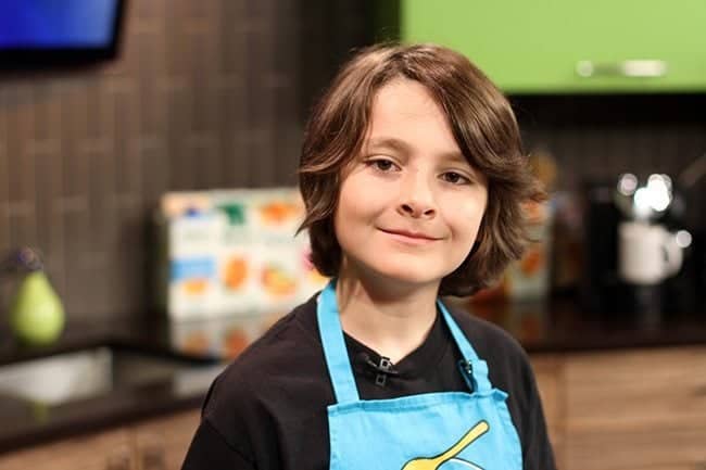 close up of young boy wearing his kitchen apron
