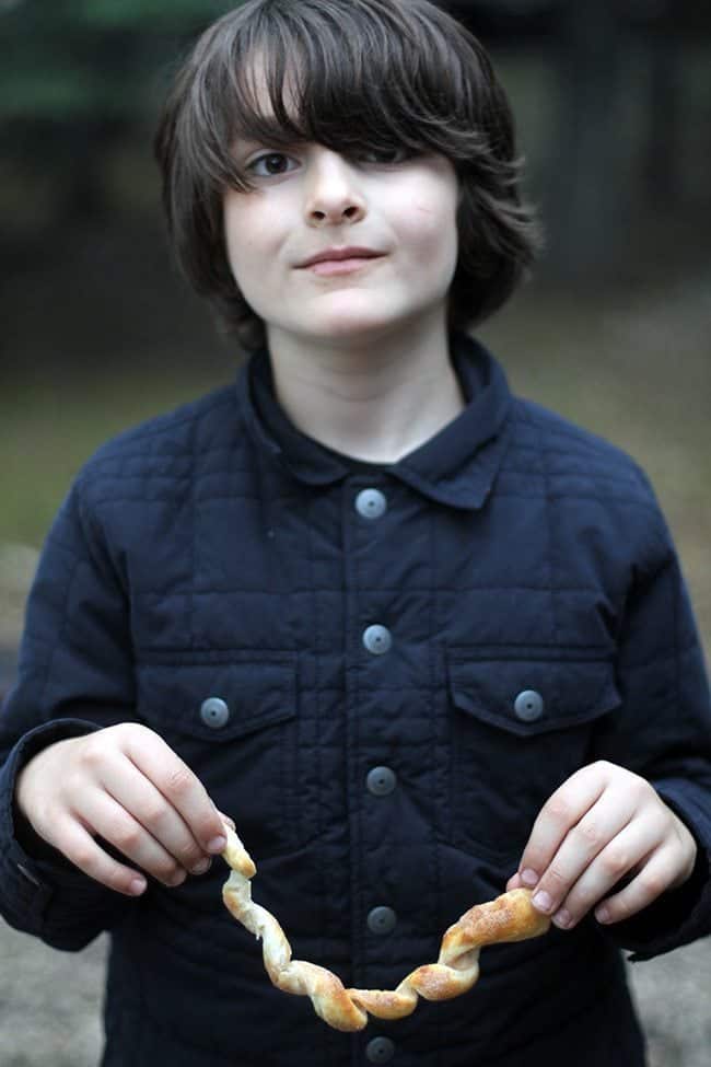 young boy holding the curled Campfire Brown Bear in both ends