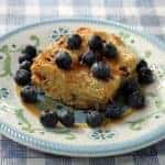 close up of Baked French Toast with maple syrup and fresh blueberries in small dessert plate