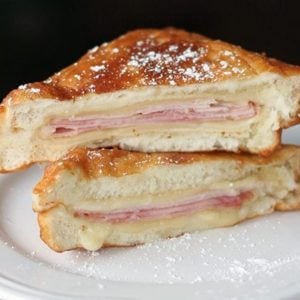 close up sliced Disneyland Monte Cristo Sandwiches with icing sugar in a white plate