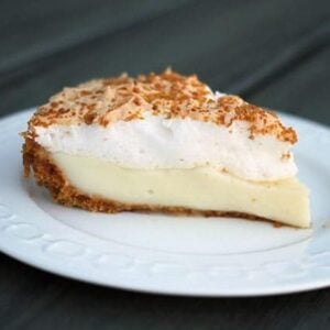 A slice of Flapper Pie in a White Plate with cinnamon laced graham crumbs on top