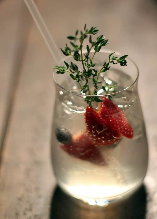 a glass of Spanish Gin and Tonic cocktail garnish with fresh strawberry slices