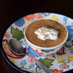 a bowl of Pumpkin Soup topped with whipping cream, sprinkled with pepper and salt