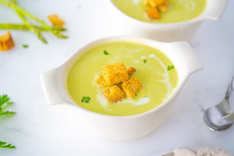Cream of Asparagus Soup in a White Bowl topped with Cube Sliced Croutons