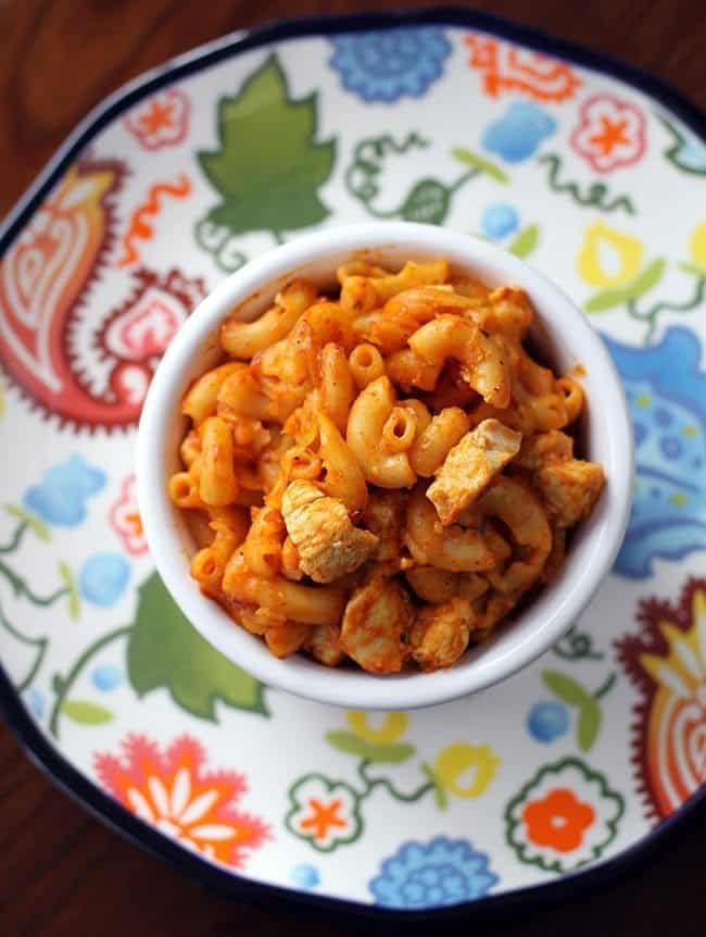 top down shot of Chicken Tikka Masala Pasta in white ramekins on a colorful small plate