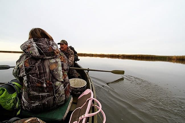 Man rowed the marsh boat and placed the decoys in the water
