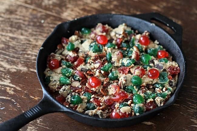 cookie dough in the skillet mixed with pecans and the chopped cherries