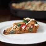 a slice of Christmas Fruitcake Chocolate Chip Skillet Cookie in a white dessert plate