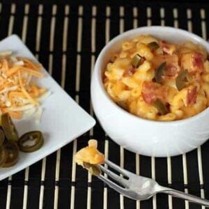 a plate of grated cheese and sliced Jalapeno, and a serving dish with Mac and Cheese